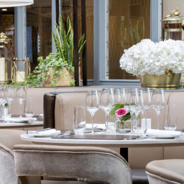 Elegant dining area with plush seating, fresh flowers, and ambient lighting, ideal for gatherings.