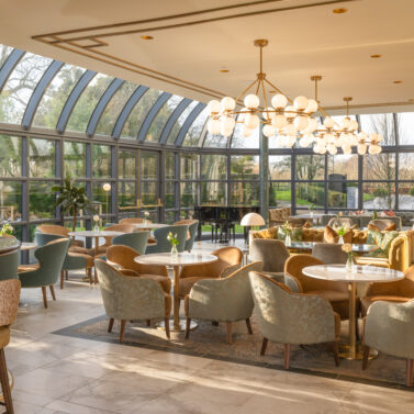 Elegant hotel lounge with large windows and comfortable seating, inviting ambiance.