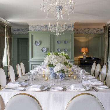 Elegant dining room with a long table set for a family gathering in a sophisticated hotel.