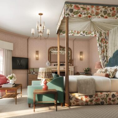 Elegant hotel room with canopy bed, floral decor, and cosy seating area.