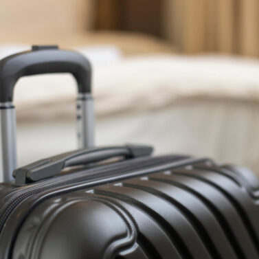 Stylish suitcase on a hotel room floor, creating a warm, inviting travel atmosphere.