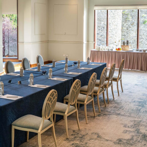Elegant conference room with neatly arranged tables and chairs, offering a bright, inviting atmosphere.