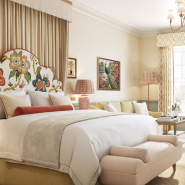 Elegant hotel room with floral decor, cosy seating, and warm lighting for a relaxing stay.