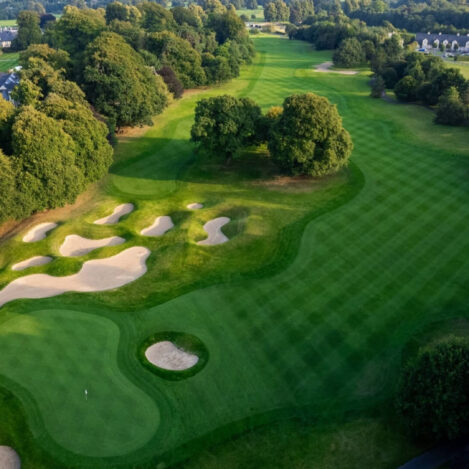 Lush, scenic golf course surrounded by trees, ideal for a relaxing family holiday.