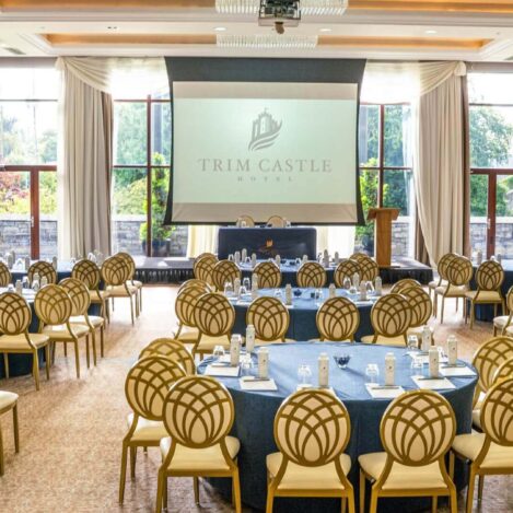 Elegant conference room with round tables, chairs, and a scenic garden view at Trim Castle Hotel.