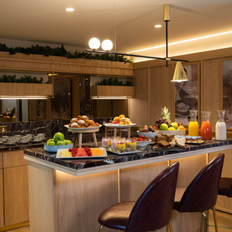 Breakfast buffet with fresh fruits, pastries, and drinks in a welcoming hotel dining area.
