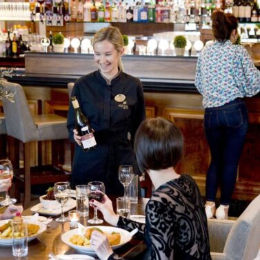 Group enjoying dinner with friendly service in a welcoming hotel restaurant setting.